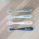 Set of BEABA baby spoons on a wooden surface