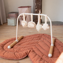 Baby play gym with hanging toys on a wooden floor